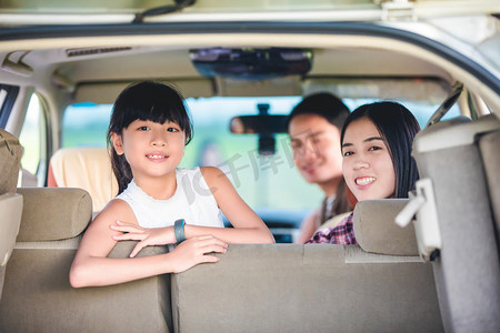 快乐的小女孩，与亚洲的家人坐在车里的援助