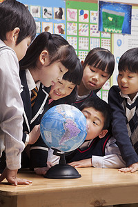 张思德摄影照片_看着一个地球仪在教室里的学生