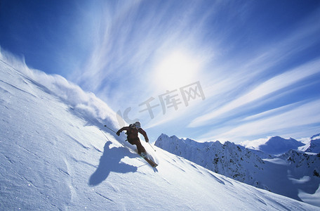 男人滑雪摄影照片_在山坡上滑雪的人