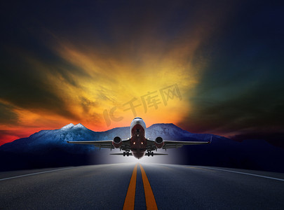 喷气式客机摄影照片_喷气式飞机飞越跑道对岩石山和美丽