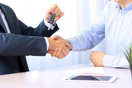 商务握手摄影照片_汽车推销员交出年轻上一篇新车钥匙