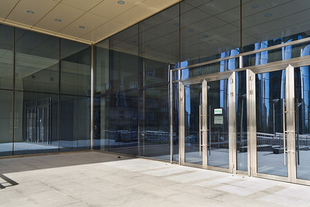 银行门口摄影照片_现代大型玻璃建筑中闭的门