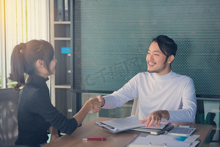 在会议中或在办公室里，业务伙伴关系会议概念谈判业务人握手.