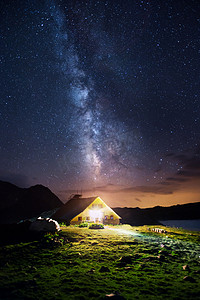 风景宇宙摄影照片_在夜幕下银河在山中小屋