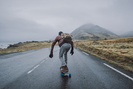 滑冰者旅行冰岛在他的长板