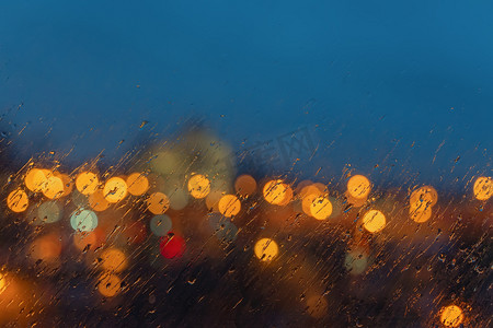 抽象模糊的风景画的背景。 夜景不再聚焦，城市的灯光透过窗户洒下雨滴