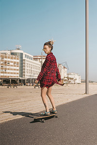 葡萄牙长板的太阳镜和衬衫溜冰的年轻女子