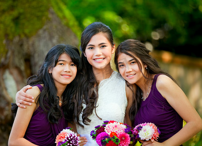 女孩抱着花摄影照片_她两个新娘伴娘户外一起抱着花束