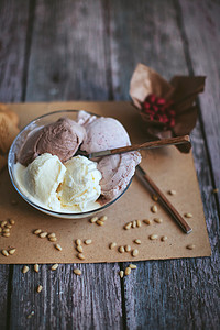 香草，巧克力，浆果冰淇淋在一个碗里用勺子木制的桌子上