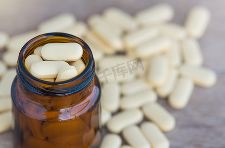 药物背景摄影照片_丸或维生素在药瓶上木背景