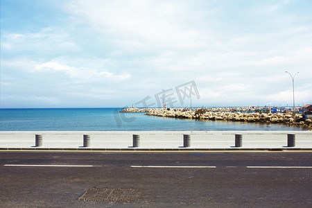 海滨长廊摄影照片_沥青路面附近的港口和海上的长廊