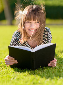 快乐的女人阅读本书在公园