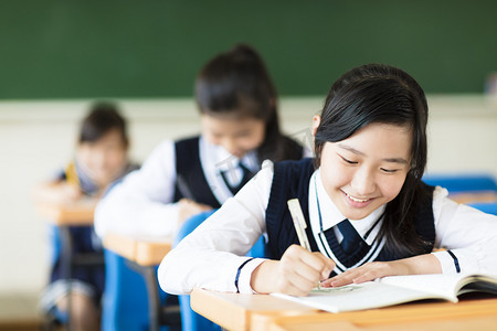 初中语文摄影照片_微笑在教室里的学生女孩和她的朋友在背景中