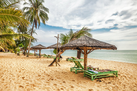 木制椅子和遮阳伞在白色的沙滩上 