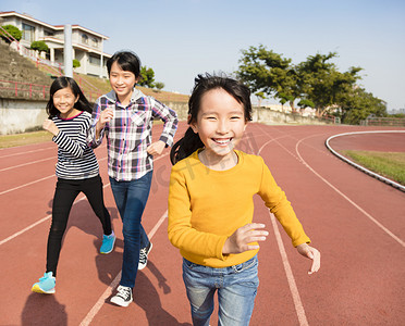 运动孩子摄影照片_快乐的小女孩，在轨道上运行