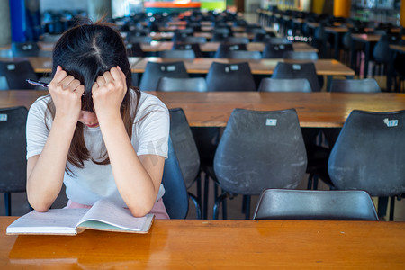 独自坐在学校桌旁的女孩感到孤独，觉得太孤独.