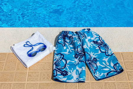 泳裤泳镜和毛巾在池