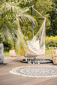 一个舒适的吊床, 枕头在一个绿色花园的甲板上, 在一个豪华的酒店夏季假期.