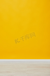 黄色风格摄影照片_明亮的空黄色墙壁与木地板 