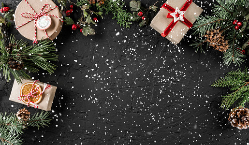 创意布局框架由圣诞树树枝, 松果, 黑暗背景上的礼物。圣诞节和新年主题, 雪。平面布局, 顶部视图, 宽构图