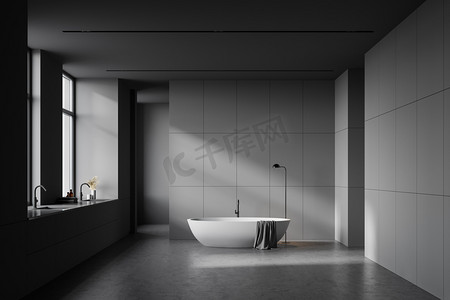 有灰色墙壁、混凝土地面、白色浴缸和靠近两扇窗户的双层水池的宽敞浴室的内部。3d渲染