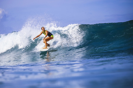 夏日旅行摄影照片_对令人惊异的蓝色波浪冲浪女孩