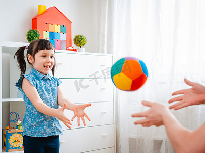 小女孩在儿童游戏室里玩耍，扔球。互动的概念父母和孩子，沟通，相互游戏，隔离，自我隔离的家，教育.