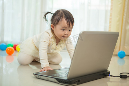 小亚洲女孩玩手提电脑在家里