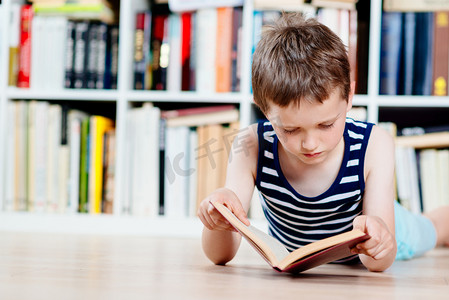 七岁的小男孩在图书馆看书.