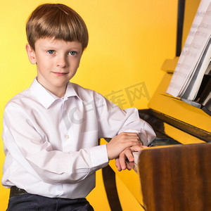 摄影照片_小男孩钢琴。钢琴演奏者.