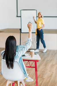 演讲人物摄影照片_学生举手回答教师问题的后视图