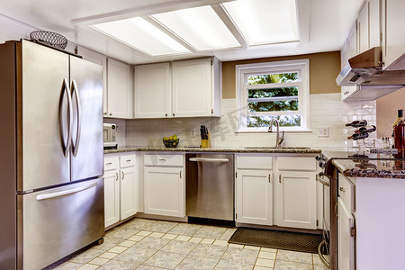 制冷摄影照片_白色的厨房配备钢电器和瓷砖后挡板三
