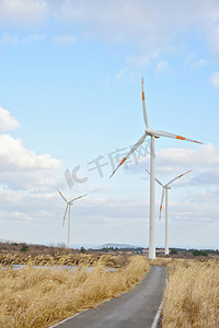 风吹摄影照片_电力电源风力发电机组在多云的天空