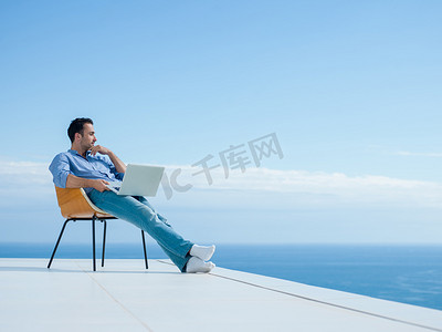 joven摄影照片_在阳台上放松的年轻人