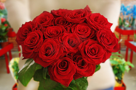 女手束美丽的红玫瑰鲜花店背景
