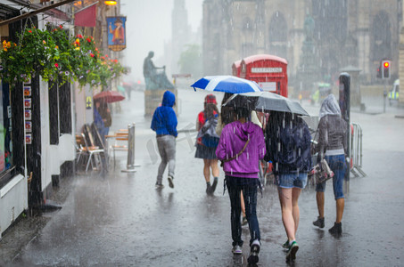 一群女孩在夏天的雨，在城市中行走