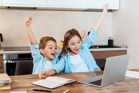 在家里边看视频边看笔记本电脑的快乐孩子的选择性焦点