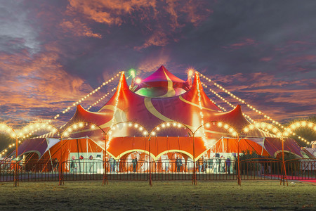 嘉年华,摄影照片_Night view of a circus tent under a warn sunset and chaotic sky