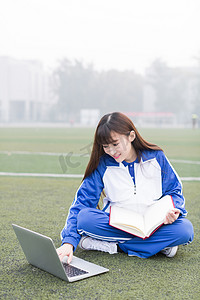 可爱的中国女高中生在校园操场上学习