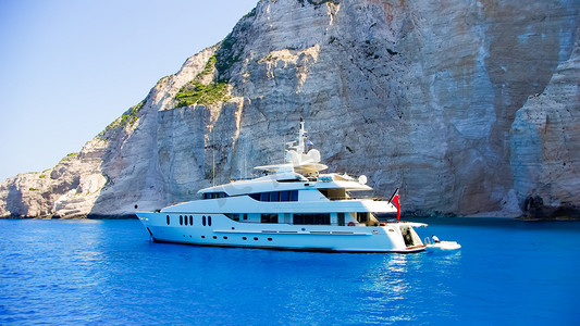 白色的豪华游艇导航到美丽的蓝色水附近扎金索斯