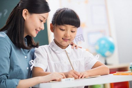 简历小学生摄影照片_老师在指导小学女生学习