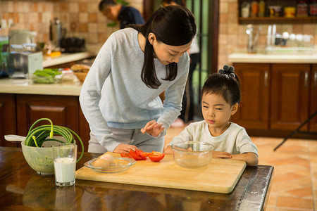 妈妈教孩子做饭摄影照片_小女孩帮妈妈做家务