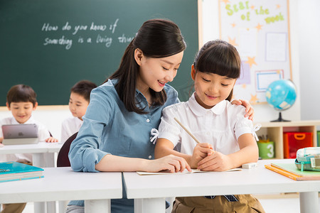 教师节黑板写字摄影照片_老师和小学生们在教室里