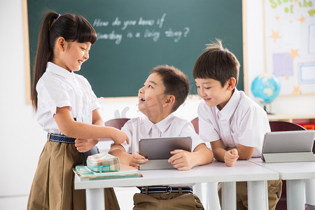 暖色调电脑壁纸摄影照片_小学生在使用平板电脑