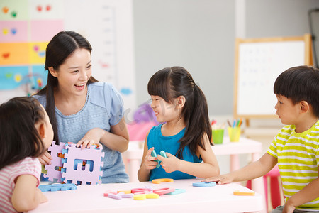 幼儿园家长会摄影照片_老师和儿童在娱乐室玩耍