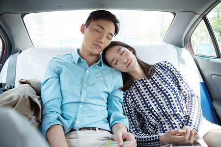 眼睛度假摄影照片_青年情侣坐在车里睡觉