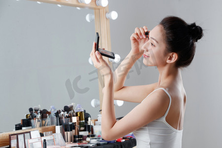 睫毛图片摄影照片_年轻女人在化妆间里化妆
