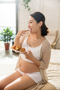 孕妇饮食摄影照片_孕妇正在吃面包