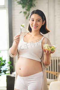 孕妇饮食摄影照片_孕妇正在吃蔬菜沙拉