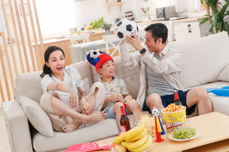电视足球摄影照片_在家看球赛兴奋的一家人